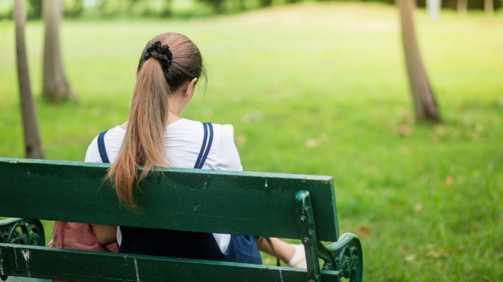 公園のベンチでゆっくり過ごす女性